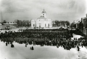 Suuri määrä ihmisiä kokoontuneena Hämeenlinnan torille. Taustalla kirkko. Mustavalkovalokuva.