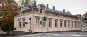 Palanderin talo. Vaalea, yksikerroksinen suurehko puutalo.